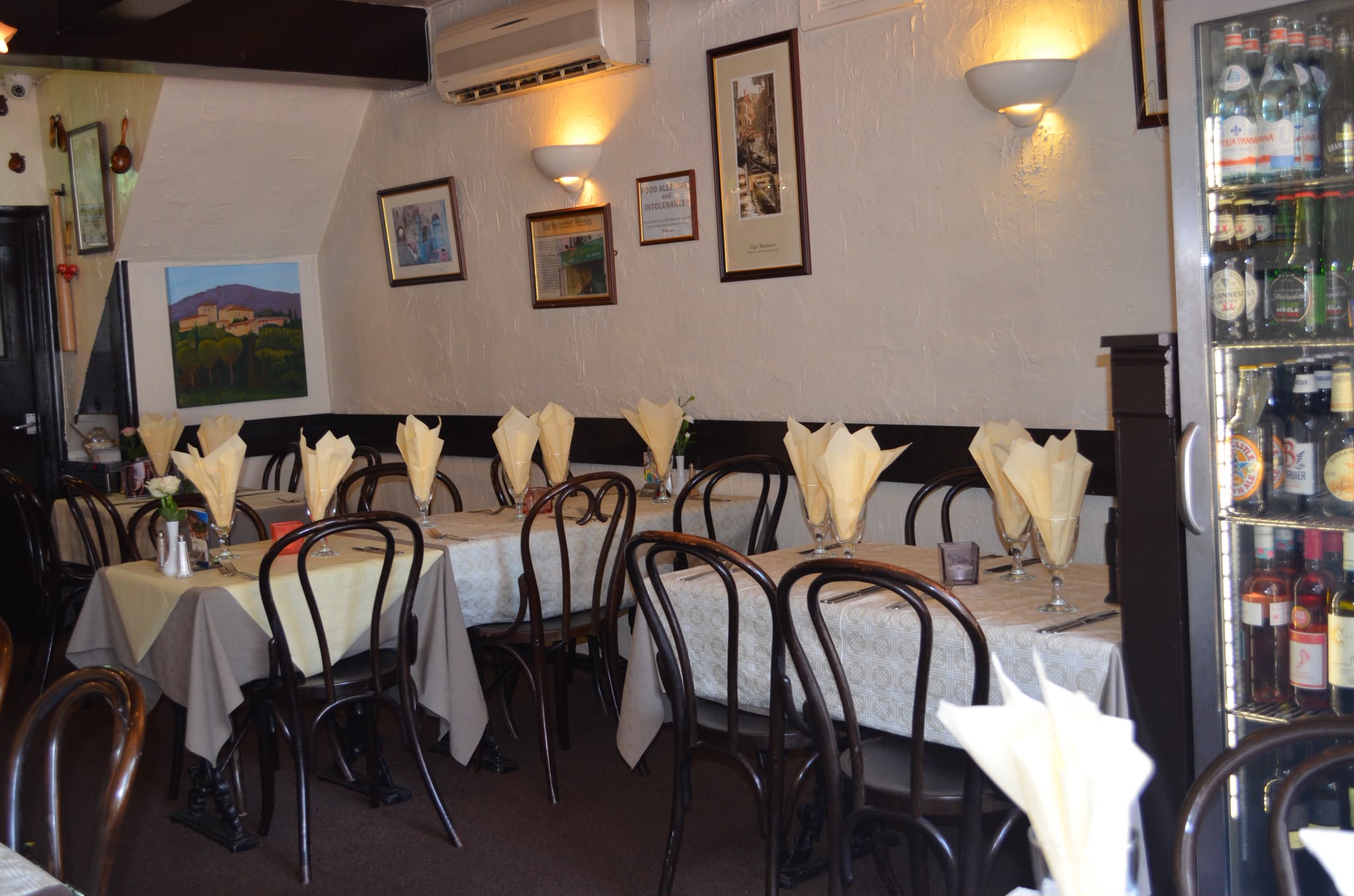 The Piccolos dining room with bentwood chairs, crisp table linen and folded napkins