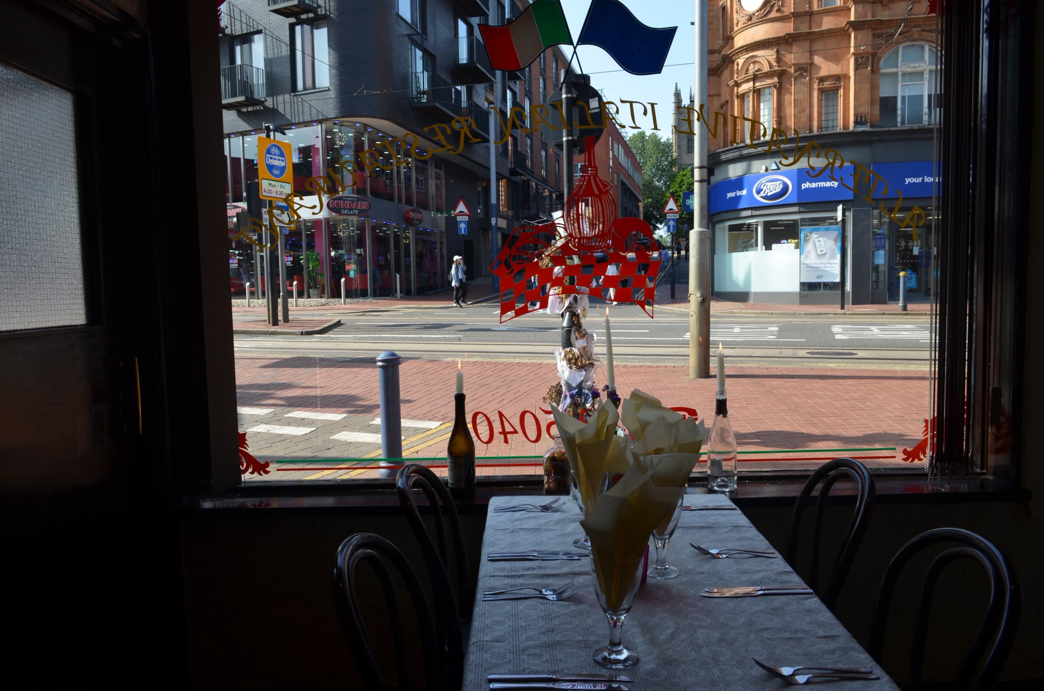 A candlelit window table at Piccolos set with wine, looking out over the street