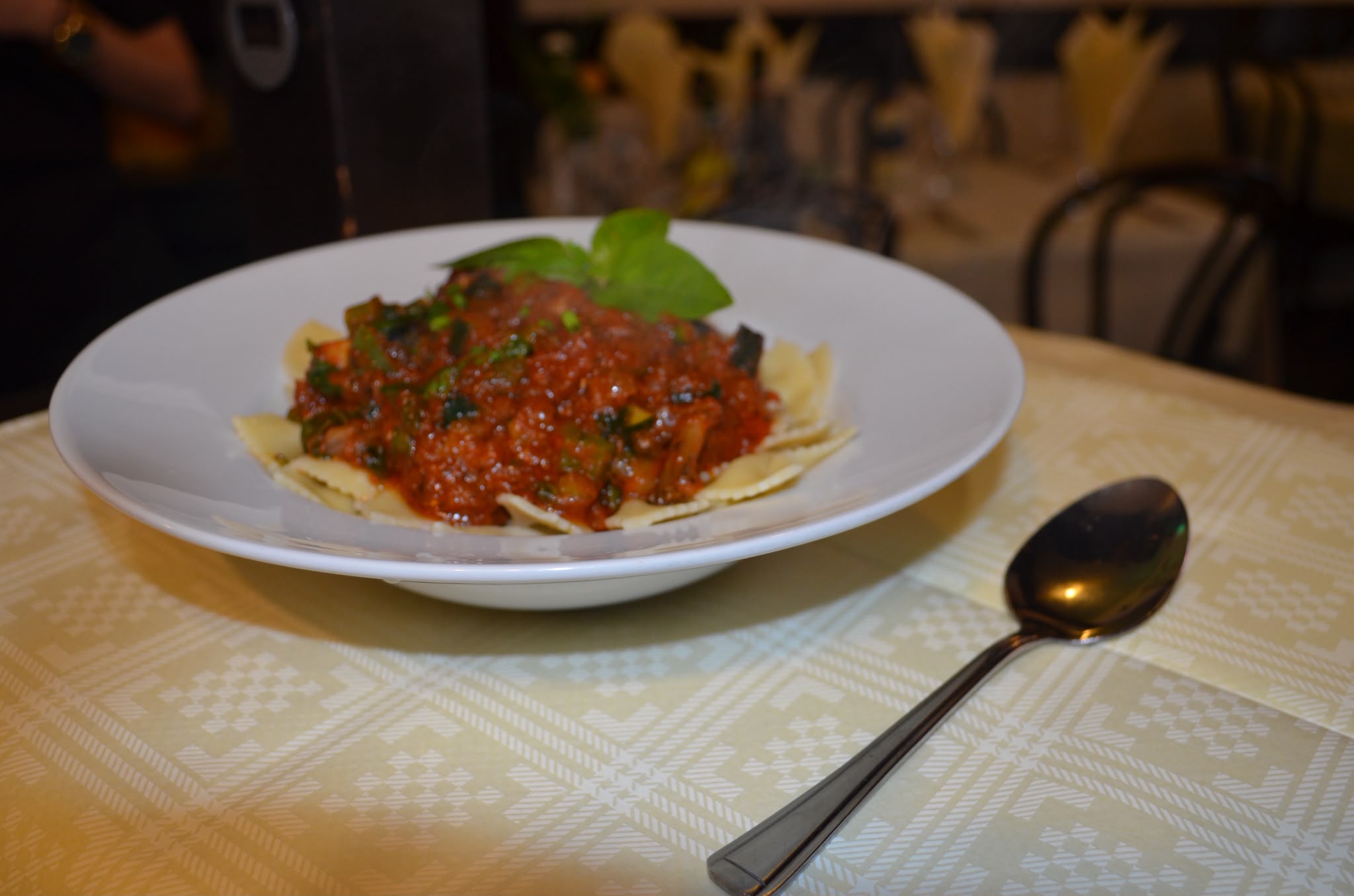 Farfalle pasta in a slow-cooked tomato and vegetable sauce, garnished with fresh basil