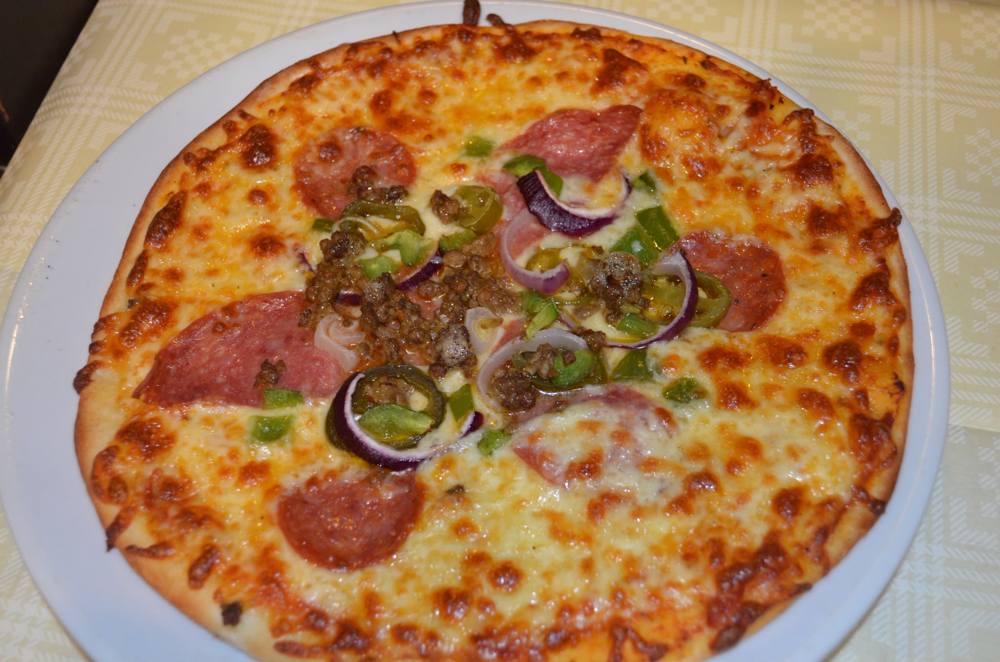 Spicy pizza topped with salami, minced beef, jalapeños, peppers and red onion