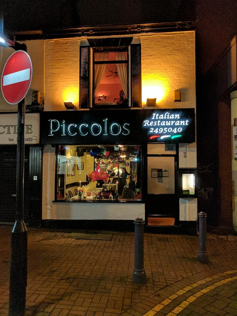 Piccolos Italian Restaurant shop front on Convent Walk, Sheffield, lit up at night